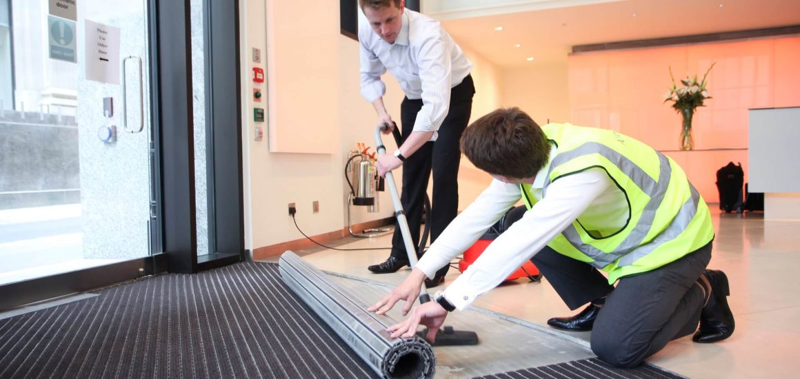 Picture showing two men cleaning the Entrance Matting with a Henry Hoover