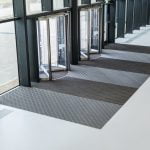 Image showing a rectangular Entrance Matting and a revolving door in an Office Building