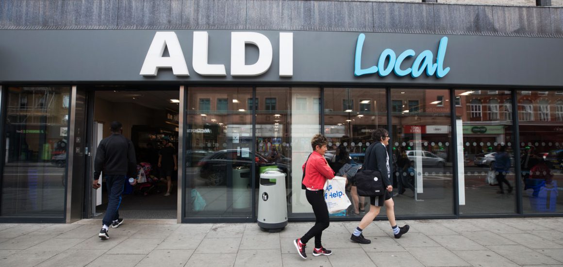 Image showing the outside of high street shop with a man in reed jumper walking past it