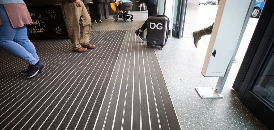 Image of a man dragging his bag on top of black Entrance Matting in a High Street store