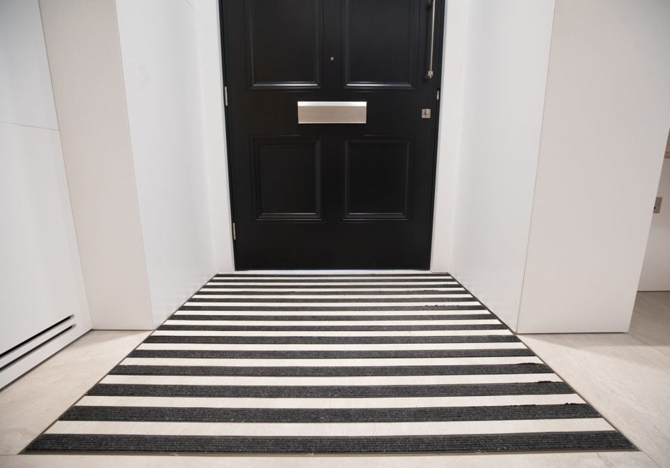 image showing a black door and entrance matting in strips at a commercial office building